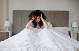 depressed woman sitting in bed