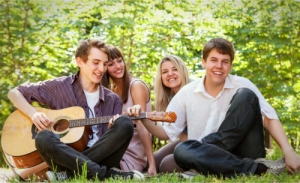 a group of teens sitting on the grass