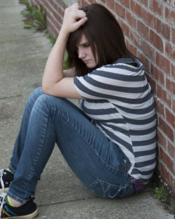 teenagerl sitting on brick wall